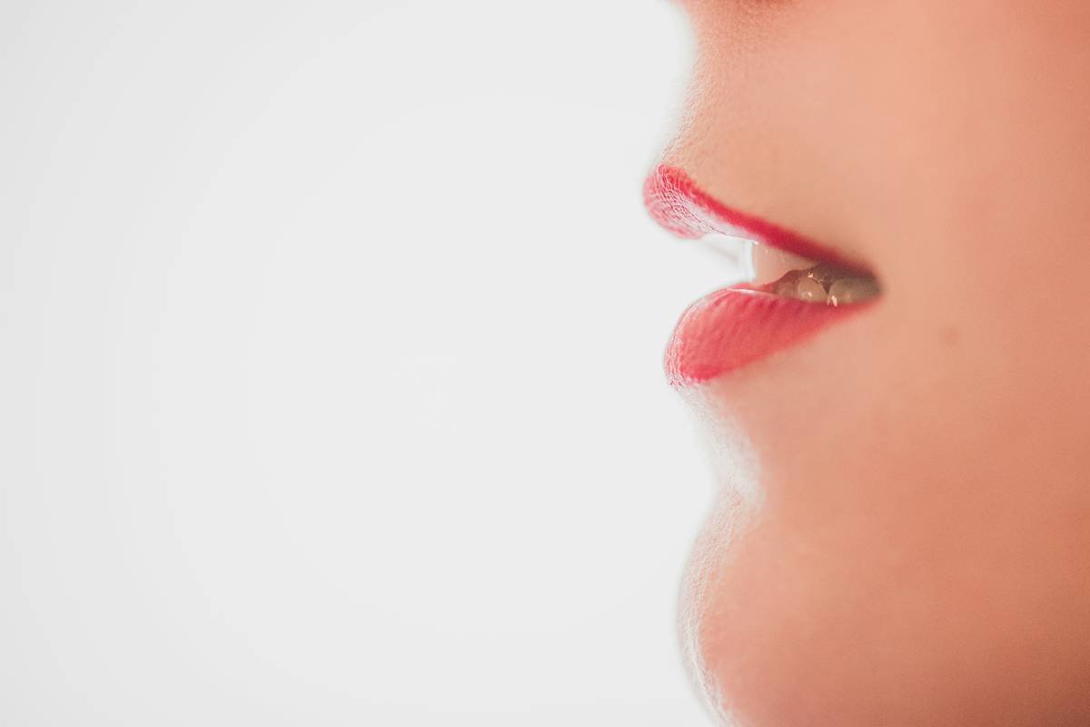 Close-up of finger blending lip liner seamlessly into lipstick showing how to blend lip liner naturally