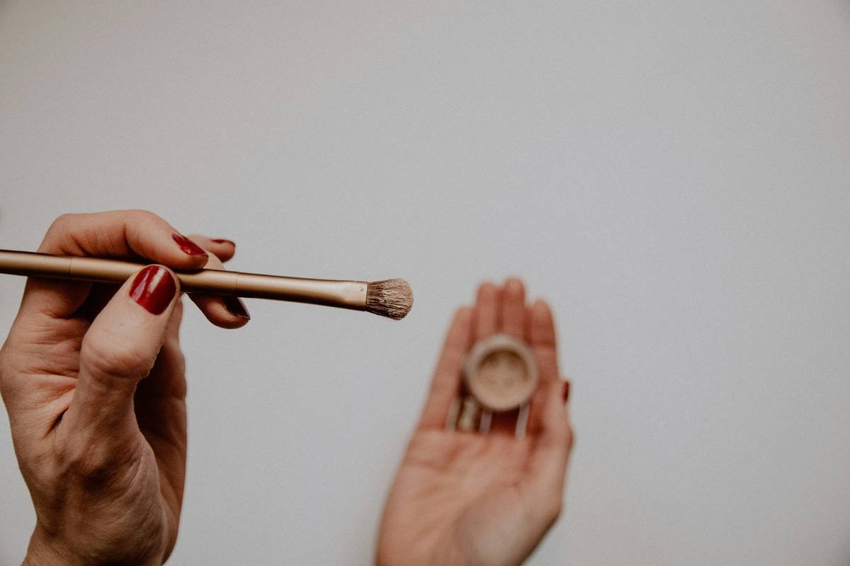 Close-up of hand applying lip enhancer liner what is plumper to upper lip contour with soft focus background